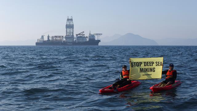 Des militants de Greenpeace confrontent le navire d'exploitation minière en eaux profondes Hidden Gem, affrété par The Metals Company, alors qu'il rentre au port après huit semaines d'exploitation minière expérimentale fin 2022. [Reuters - Gustavo Graf]