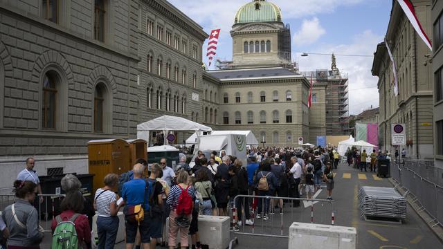 Des personnes font la queue devant le Palais fédéral dans le cadre du 175e anniversaire de la Constitution fédérale de 1848, le dimanche 2 juillet 2023, à Berne. [Keystone - Anthony Anex]