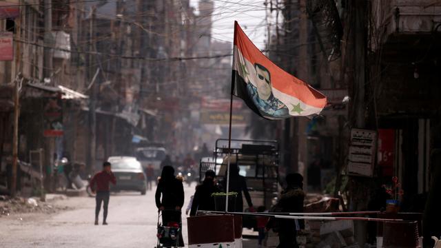 Un drapeau du président syrien Bachar el-Assad flotte sur un checkpoint à Douma, dans la périphérie de Damas. [REUTERS - Omar Sanadiki]