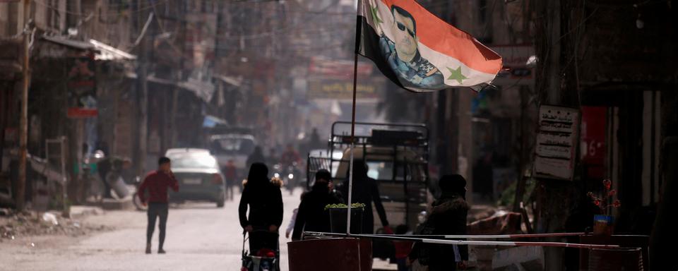 Un drapeau du président syrien Bachar el-Assad flotte sur un checkpoint à Douma, dans la périphérie de Damas. [REUTERS - Omar Sanadiki]