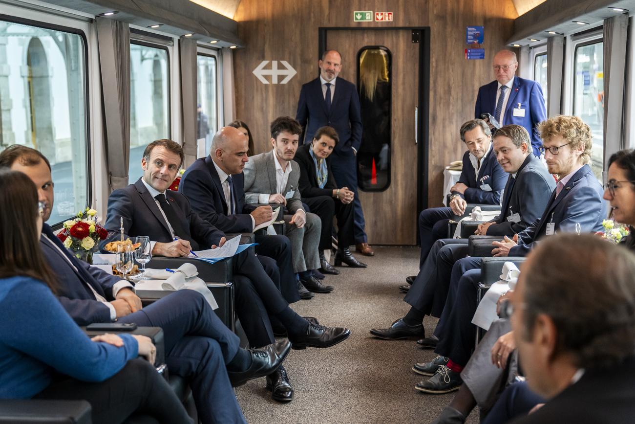 Emmanul Macron entouré de représentants de start-ups lors du trajet spécial en train jusqu'à Genève, jeudi après-midi. [keystone - Martial Trezzini]