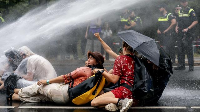 Police fire a water cannon as climate activists block the A12 for the third day in a row to demonstrate against the government's granting of fossil subsidies, in The Hague, Netherlands, 11 September 2023. Extinction Rebellion has announced that it wants to block the Utrechtsebaan on the A12 every day. [EPA - Robin van Lonkhuijsen]