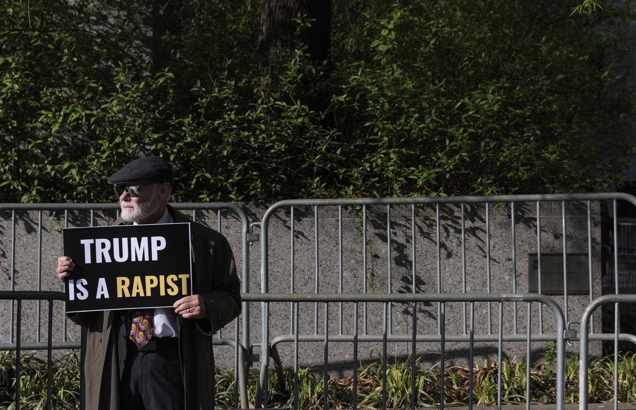 Une personne avec une pancarte "Trump est un violeur" devant le tribunal civil new-yorkais, le 25 avril 2023. [Keystone - Justin Lane]