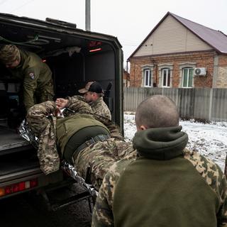 Des soldats ukrainiens évacuent un blessé près de la ligne de front dans la région de Donetsk. [Reuters - Viacheslav Ratynskyi]