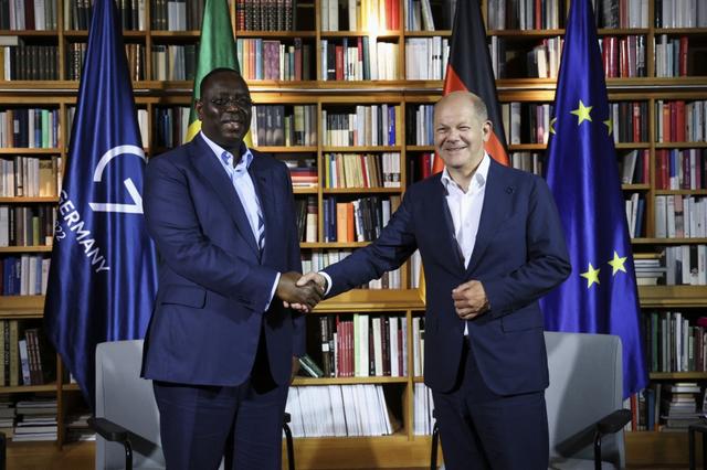 Poignée de mains entre le président sénégalais Macky Sall et le chancelier allemand Olaf Scholz lors d'une réunion bilatérale en marge du sommet du G7, le 27 juin 2022. [AFP - Lukas Barth]