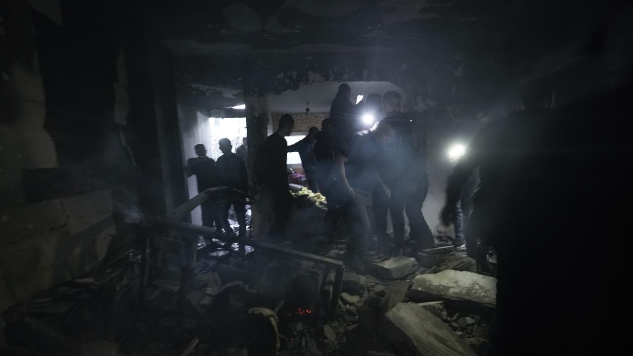 Des Palestiniens inspectent la maison touchées par deux roquettes lors du raid israélien. [AP Photo - Majdi Mohammed]