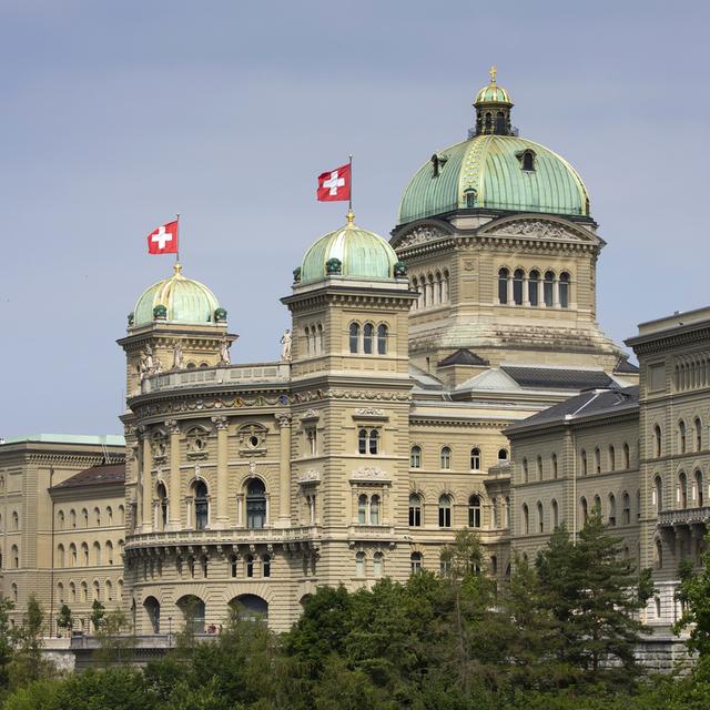 Deux drapeaux suisses flottent sur le Palais fédérale à Berne le 9 juillet 2019. [Keystone - Peter Klaunzer]