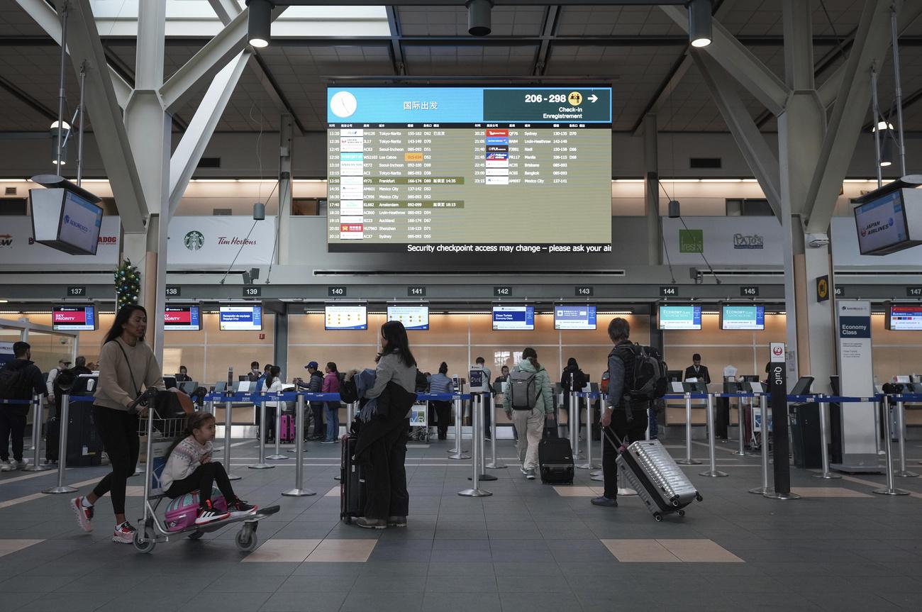 Des passagers dans l'ère d'enregistrement à l'aéroport de Vancouver, le 26 décembre 2022. [AP/Keystone - Darryl Dyck]