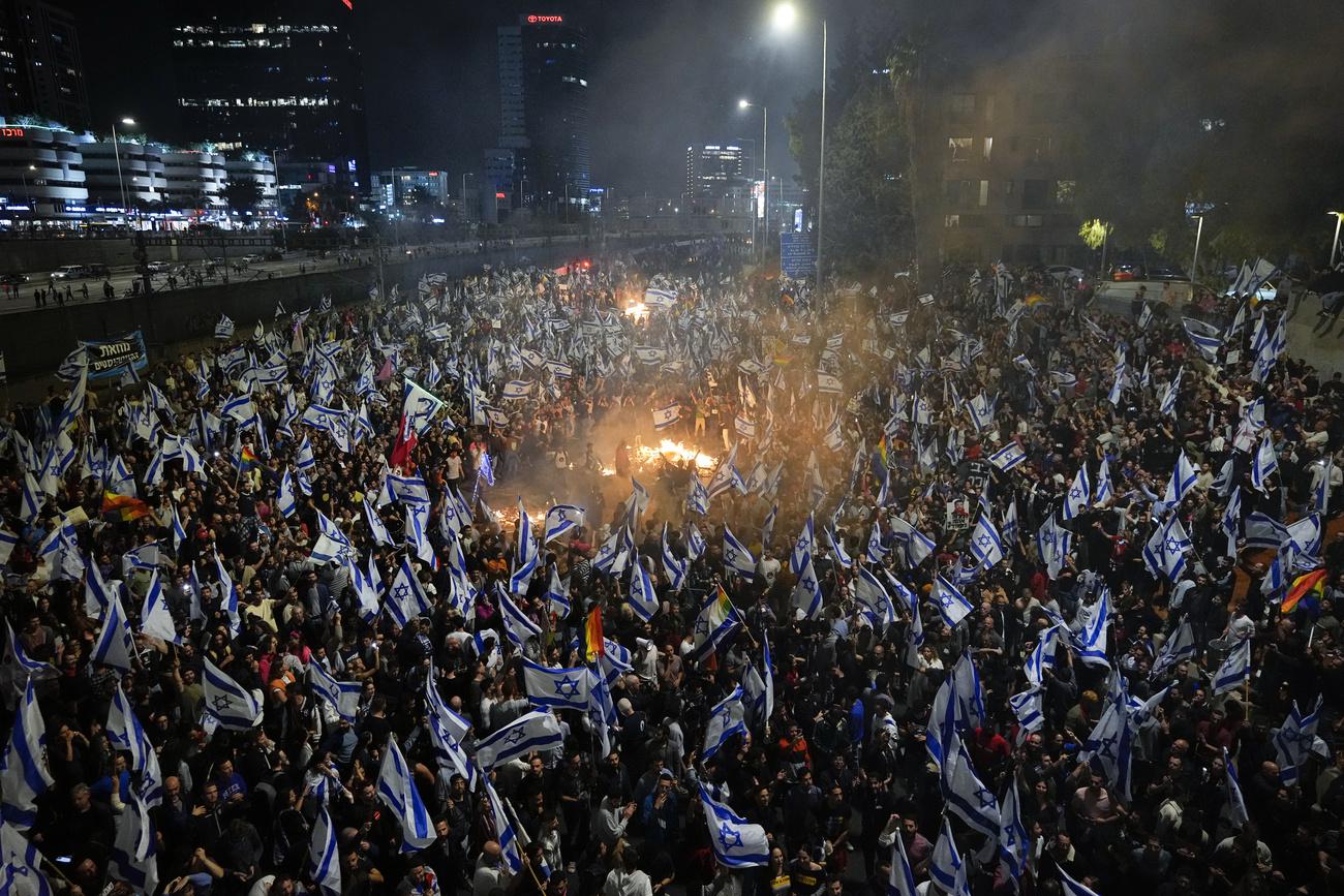Des milliers d'Israéliens sont allés manifester dans la rue après le limogeage de Yoav Galant. [Keystone/AP - Ohad Zwigenberg]