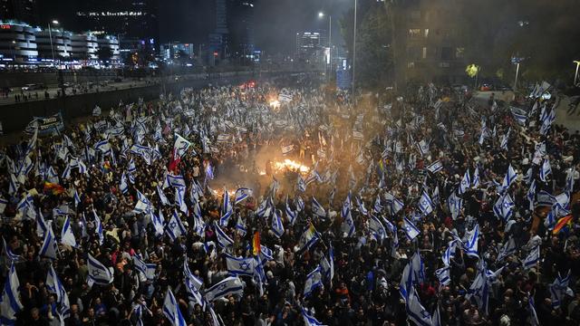 Des milliers d'Israéliens sont allés manifester dans la rue après le limogeage de Yoav Galant. [Keystone/AP - Ohad Zwigenberg]