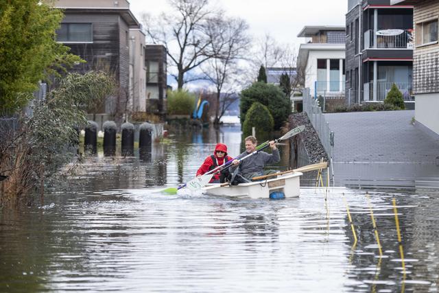 Mercredi 13 décembre: des habitants pagayent avec leur bateau pendant la crue dans le quartier de Ried à Giswil, au bord du lac de Sarnen dans le canton d'Obwald. [Keystone - Urs Flueeler]