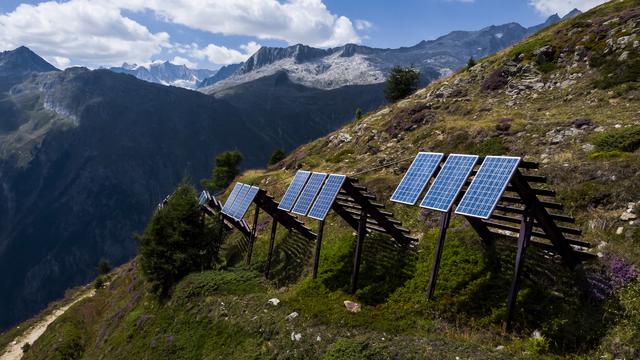 Une vue sur les panneaux solaires installés sur des paravalanches dans les alpes valaisannes à Bellwald le 3 août 2022. [Keystone - Jean-Christophe Bott]