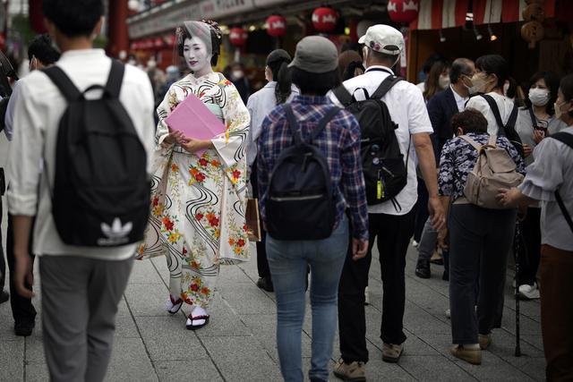 Une geisha dans une rue de Tokyo. [Keystone - AP Photo/Eugene Hoshiko]