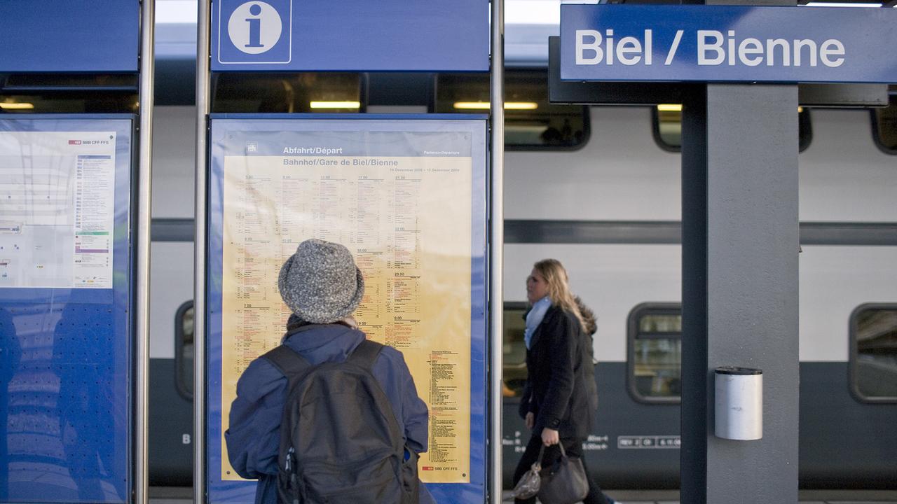 Une femme consulte un horaire CFF à la gare de Bienne le 27 novembre 2009. [Keystone - Gaetan Bally]