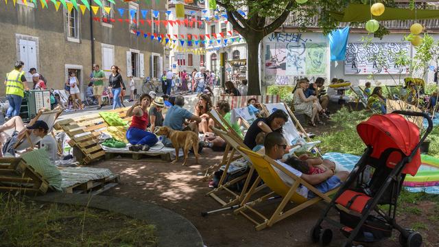 Des personnes profitent d'un espace détente en 2018 pour célébrer la nouvelle place des Grottes. [Keystone - Martial Trezzini]