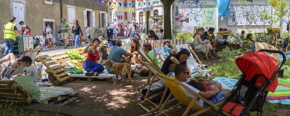 Des personnes profitent d'un espace détente en 2018 pour célébrer la nouvelle place des Grottes. [Keystone - Martial Trezzini]