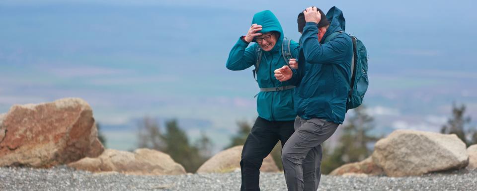 Un couple de touristes face au vent. [Keystone - DPA/Matthias Bein]