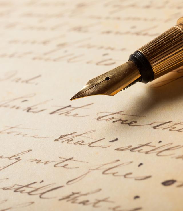 Un stylo-plume au dessus d'une feuille manuscrite. [Depositphotos - minervastock]