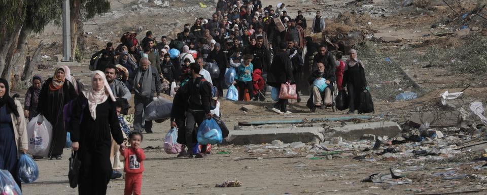 La population palestinienne, déplacée et réfugiée à cause des bombardements intensifs depuis Israël, parcourt la bande de Gaza du Nord au Sud dans l'espoir de retrouver leurs proches. [Keystone/EPA - Mohammed Saber]