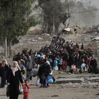 La population palestinienne, déplacée et réfugiée à cause des bombardements intensifs depuis Israël, parcourt la bande de Gaza du Nord au Sud dans l'espoir de retrouver leurs proches. [Keystone/EPA - Mohammed Saber]