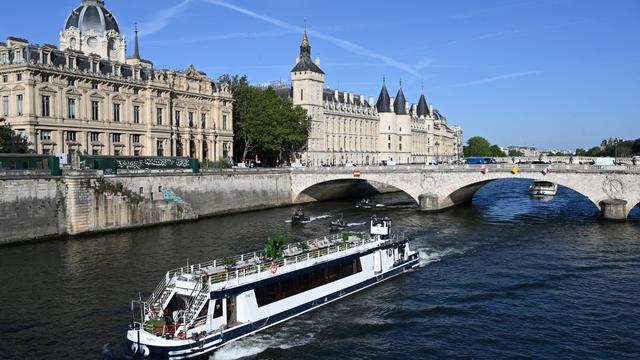 Un bateau péniche passe devant le Quai de l'Horloge lors d'un défilé sur la Seine à Paris le 17 juillet 2023, pour tester de "manœuvres" avant les JO 2024. [AFP]