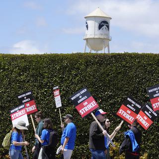 Des grévistes défilent devant les studios Paramount Pictures pour demander une revalorisation salariale et contractuelle des scénaristes à Hollywood. [Keystone/AP Photo - Chris Pizzello]