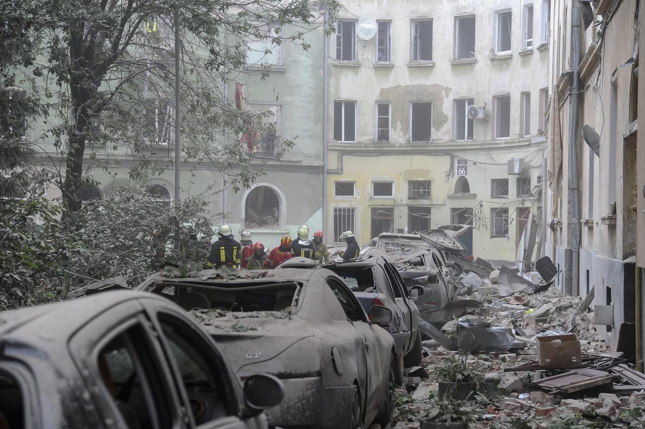 Des sauveteurs devant des bâtiments endommagés après une attaque de missiles russes à Lviv, en Ukraine, le jeudi 6 juillet 2023. [Keystone - AP Photo/Mykola Tys]