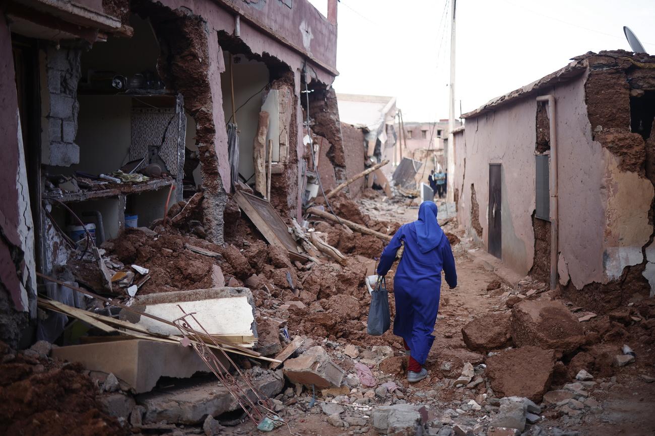 Une femme au milieu des décombres à Ouirgane, au sud du Marrakech. [Keystone - EPA/Yoan Valat]