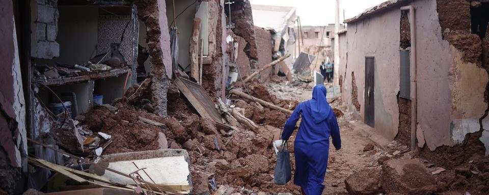 Une femme au milieu des décombres à Ouirgane, au sud du Marrakech. [Keystone - EPA/Yoan Valat]