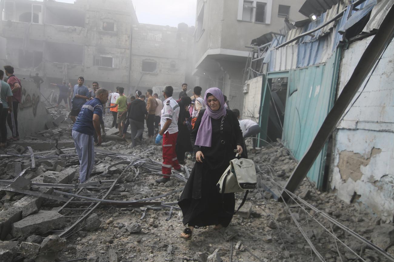 Des habitants de Gaza dans les rues après un bombardement israélien, le 12 octobre 2023. [Keystone - Hatem Ali]