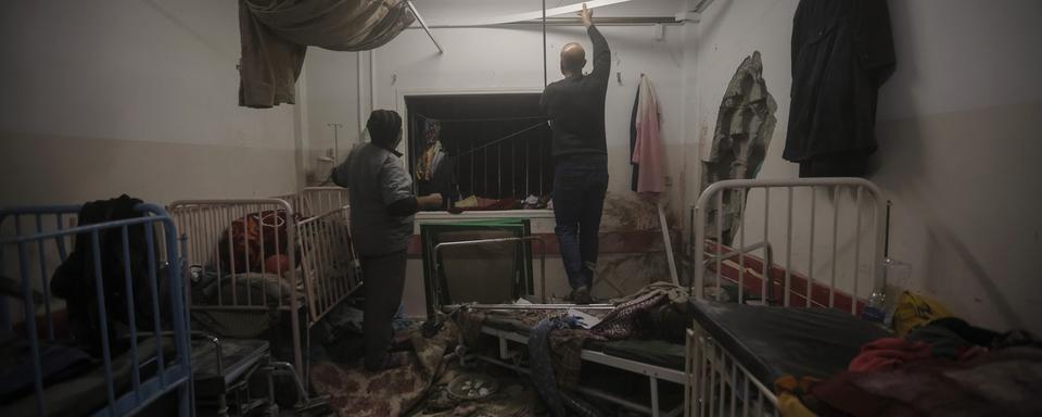 Des membres du personnel médical inspectent les dégâts après un bombardement israélien sur l'hôpital de Nasser à Khan Younis, dans la bande de Gaza, le 17 décembre 2023. [AP/Keystone - Mohammed Dahman]