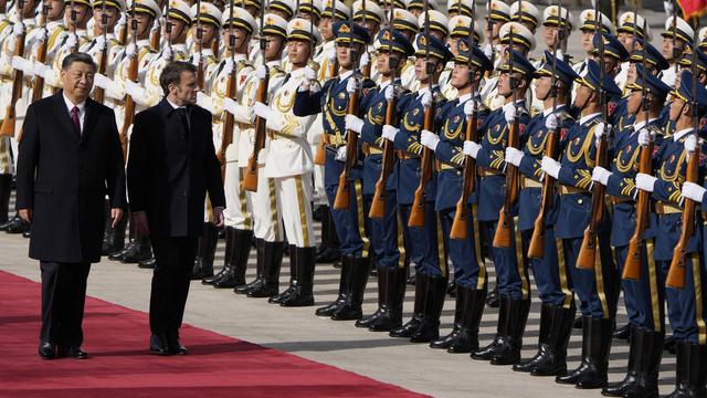 Le président français Emmanuel Macron inspecte une garde d'honneur avec le président chinois Xi Jinping à Pékin le 6 avril 2023. [Keystone - AP Photo/Ng Han Guan, Pool]