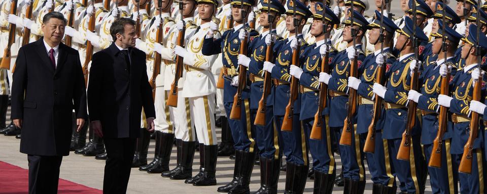 Le président français Emmanuel Macron inspecte une garde d'honneur avec le président chinois Xi Jinping à Pékin le 6 avril 2023. [Keystone - AP Photo/Ng Han Guan, Pool]