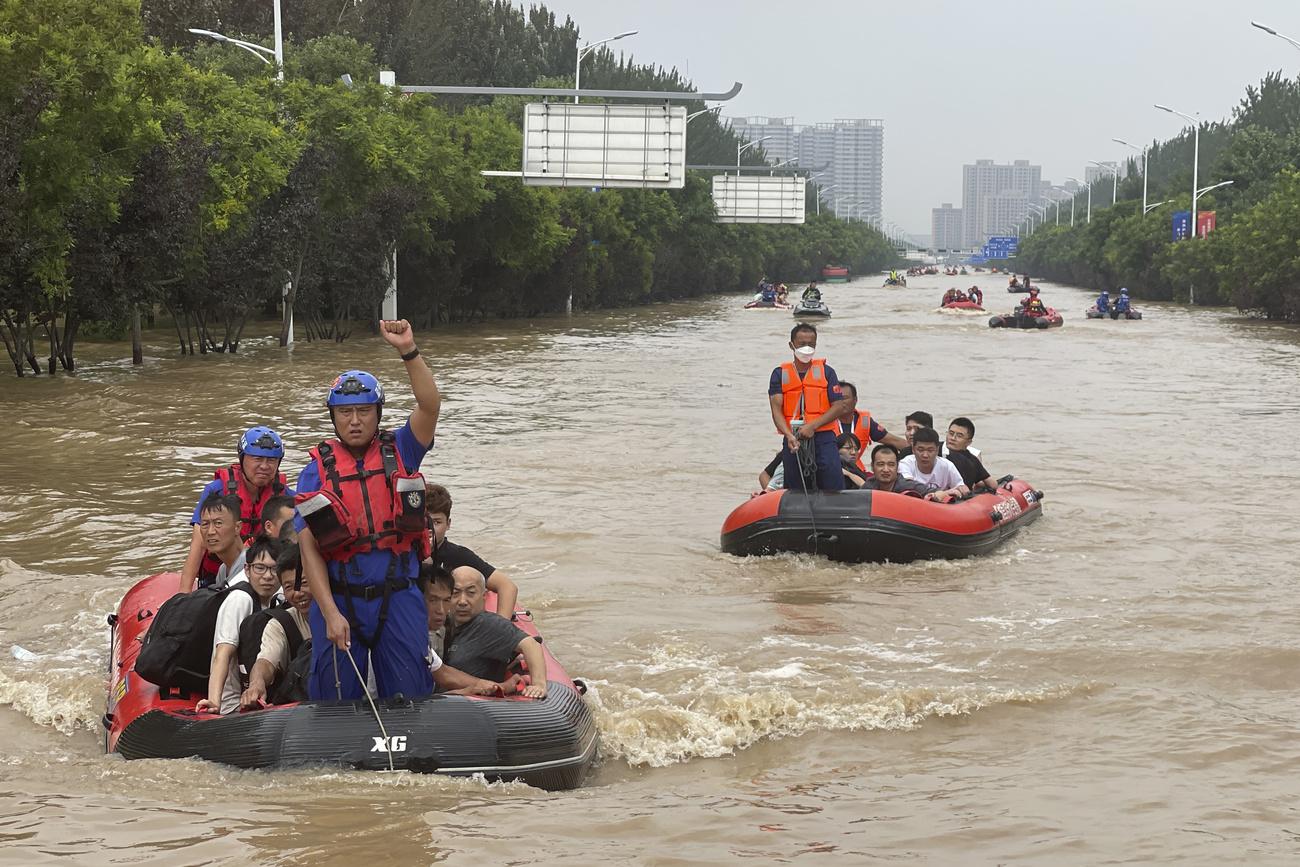 Des habitants sont évacués à travers les eaux de crue à Zhuozhou, dans la province de Hebei, au sud de Pékin. [Keystone - Andy Wong / AP Photo]