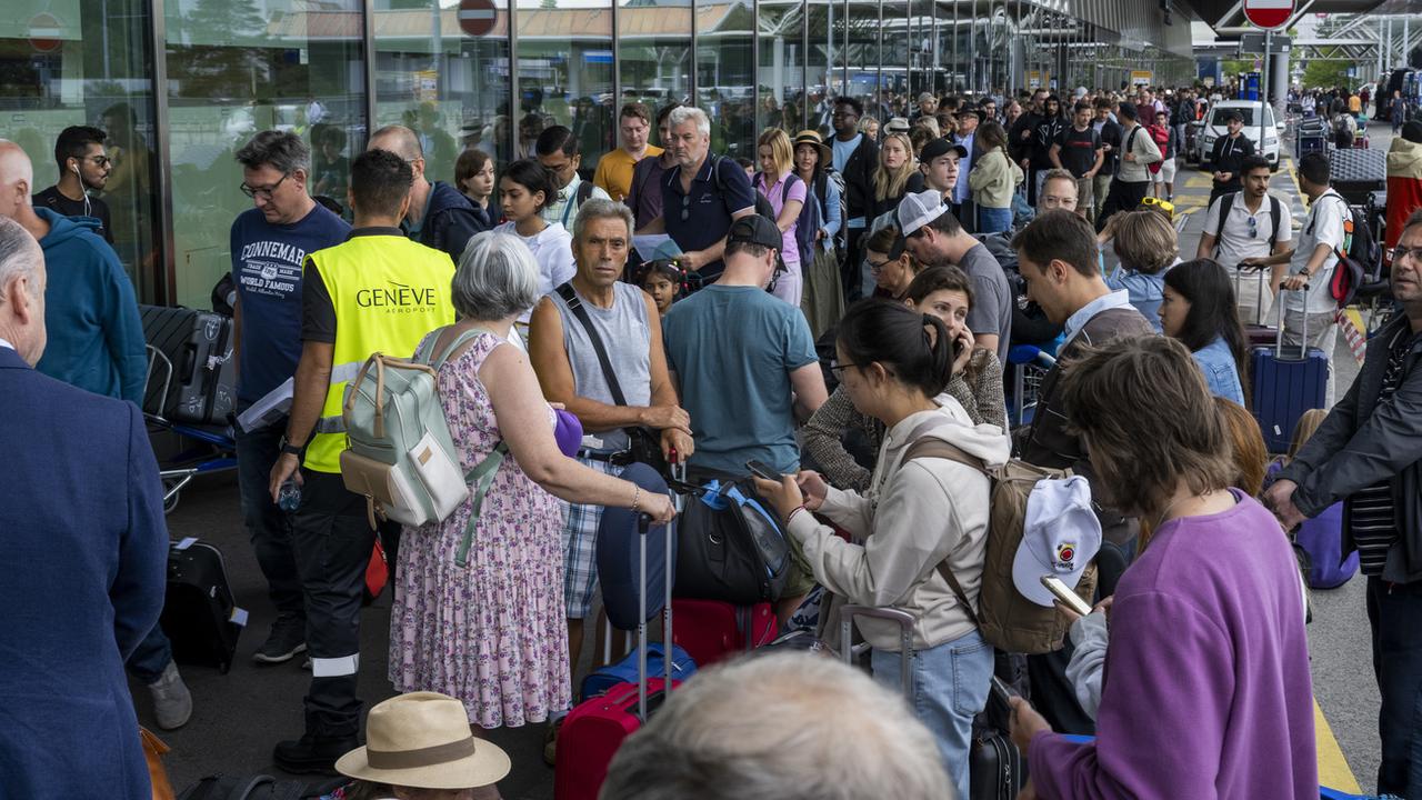 Des passagers arrivent avec leurs bagages pendant que les employés de Genève Aéroport (AIG) sont en grève, le 30 juin 2023. [Keystone]