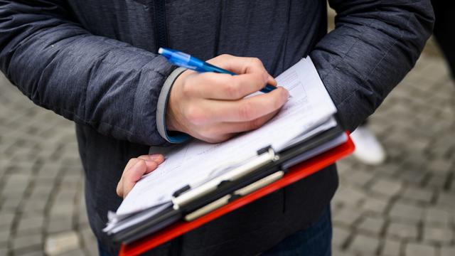 L'interdiction de la récolte de signatures contre rémunération ne doit pas être interdite, selon la commission du national. Image d'illustration. [Keystone - Jean-Christophe Bott]