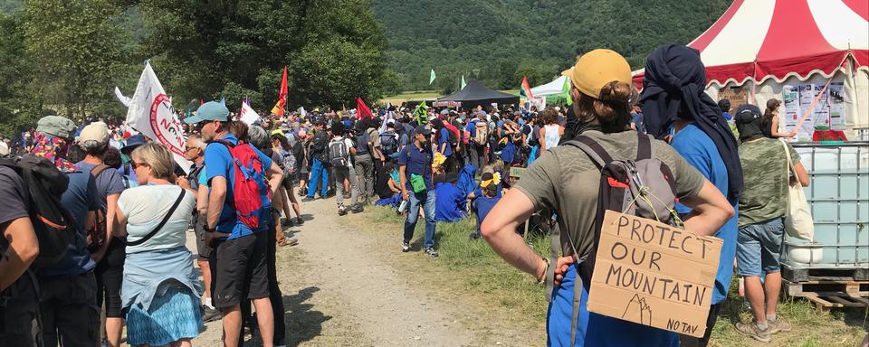 Des manifestants rassemblés pour manifester contre le chantier de ligne ferroviaire grande vitesse Lyon-Turin. [RTS - Coppelia Piccolo]