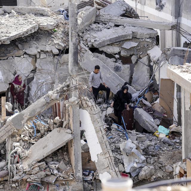 A Khuza, dans la bande de Gaza, un homme et une femme inspectent les décombres de leur maison détruite par des bombardements de l'armée israélienne, le 26 novembre 2023. [Keystone - Adel Hana]