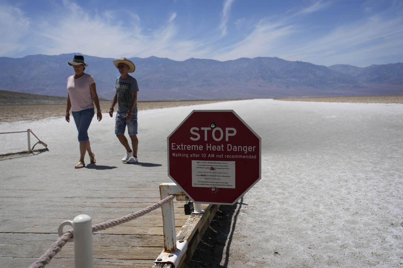 Un panneau avertit les visiteurs d'un danger de chaleur extrême à Badwater Basin, dans le parc national de la Vallée de la Mort, en Californie. [Keystone - John Locher / AP Photo]