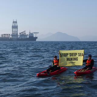 Des militants de Greenpeace confrontent le navire d'exploitation minière en eaux profondes Hidden Gem, affrété par The Metals Company, alors qu'il rentre au port après huit semaines d'exploitation minière expérimentale fin 2022. [Reuters - Gustavo Graf]
