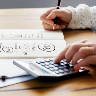 Gros plan sur la main d'une personne en train d'effectuer des calculs sur une calculatrice. [Depositphotos - Rawpixel]