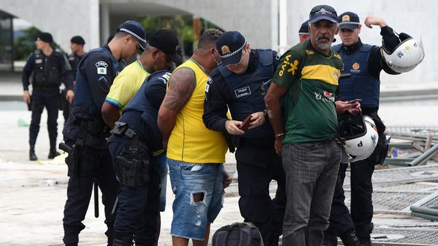 Des partisans de l'ex-président Jair Bolsonaro arrêtés par la police. [AFP - Ton Molina]