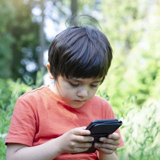 Un enfant avec un téléphone portable. [Depositphotos - annbkk.gmail.com]