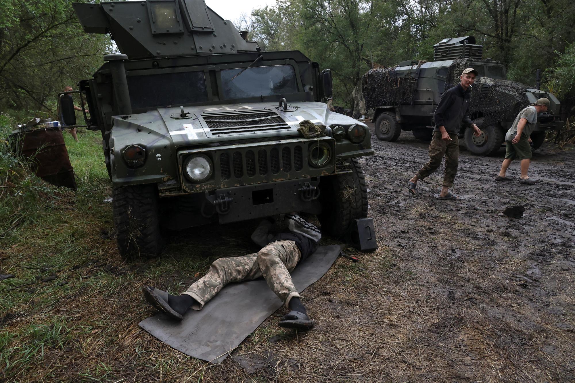 Des membres du bataillon de maintenance réparent un véhicule près d'une ligne de front, , dans la région de Donets (est) le 20 juillet 2023. [reuters - Sofiia Gatilova]