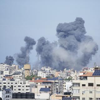 De la fumée s'élève après une explosion causée par une frappe aérienne israélienne dans la bande de Gaza, samedi 7 octobre 2023. [Keystone - AP Photo/Hatem Moussa]