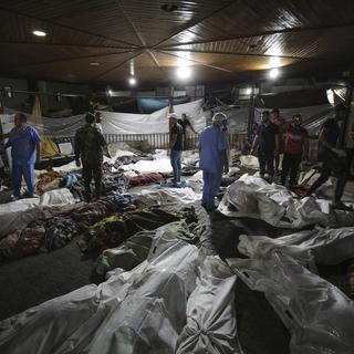 Les corps recouverts de personnes palestiniennes devant l'hôpital al-Shifa après une frappe militaire meurtrière, présumée israélienne, contre un des hôpitaux de la bande de Gaza. [Keystone/AP Photo - Abed Khaled]