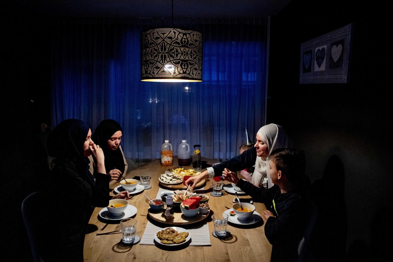 Une famille musulmane pendant l'iftar, le repas marquant la rupture du jeûne de ramadan à la tombée de la nuit. [EPA/Keystone - Robin Utrecht]