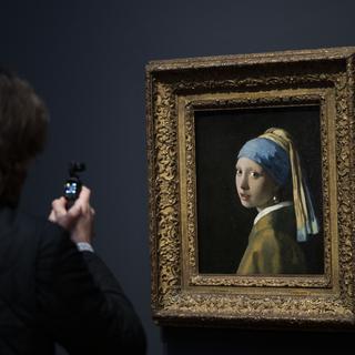 Un journaliste photographie "La jeune fille à la Perle" au Rijksmuseum. [Keystone - AP Photo/Peter Dejong]