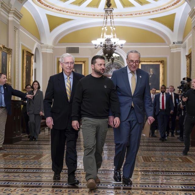 Le président ukrainien Volodymyr Zelenskyy est escorté par le chef de la minorité du Sénat Mitch McConnell, R-Ky et le chef de la majorité du Sénat Chuck Schumer, D-N.Y., le 12 décembre 2023. [KEYSTONE - J. SCOTT APPLEWHITE]