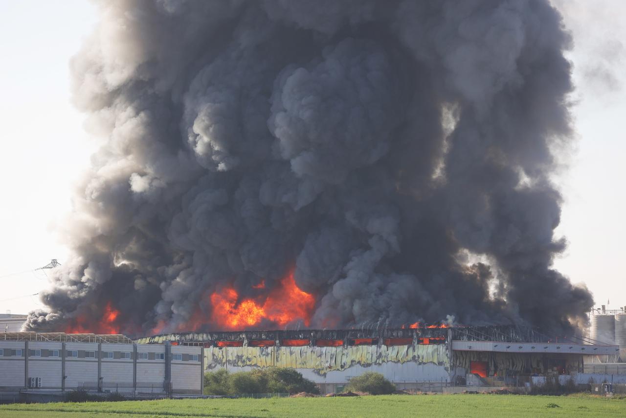 Une structure en feu après une frappe directe sur la ville israélienne de Gedera suite à des tirs de roquettes depuis Gaza, le samedi 7 octobre 2023. [Keystone - Abir Sultan]